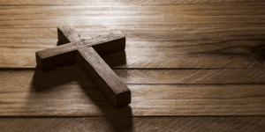 A wooden cross on a rough wooden table