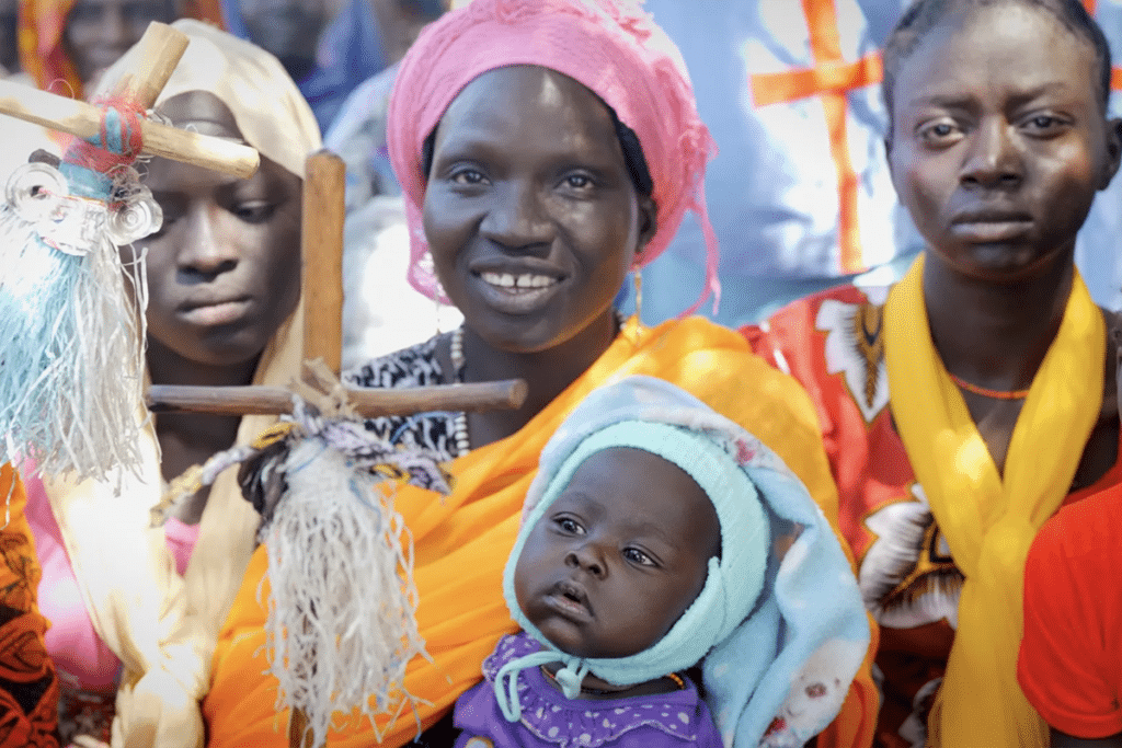 A mother holds her baby during a church service in the Nuba Mountains.