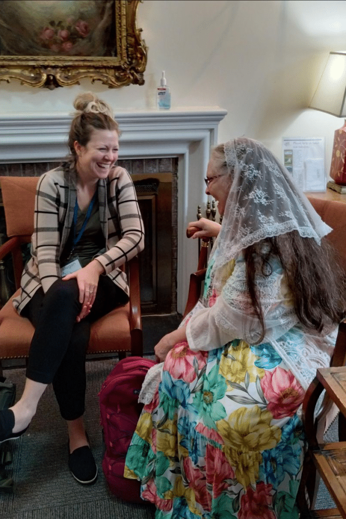 Two women chat by a fireplace at the 2023 Women's Deanery Retreat