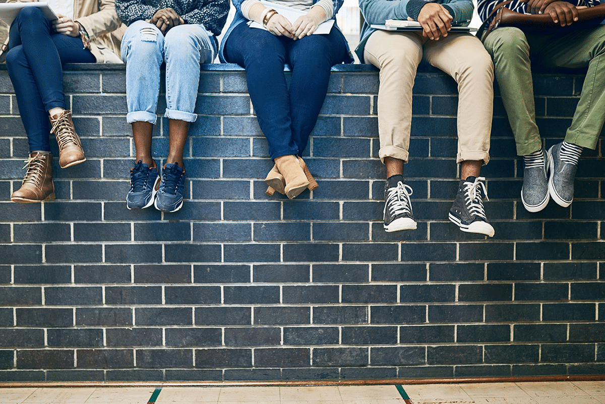 A group of young people sitting on a brick wall