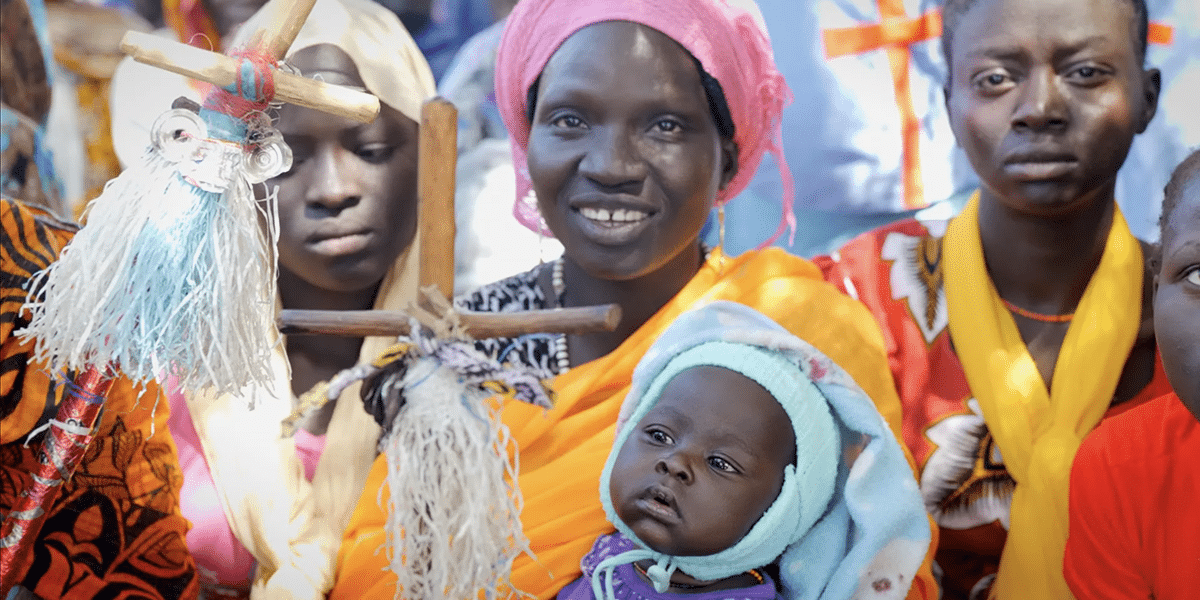 A mother holds her baby during a church service in the Nuba Mountains.